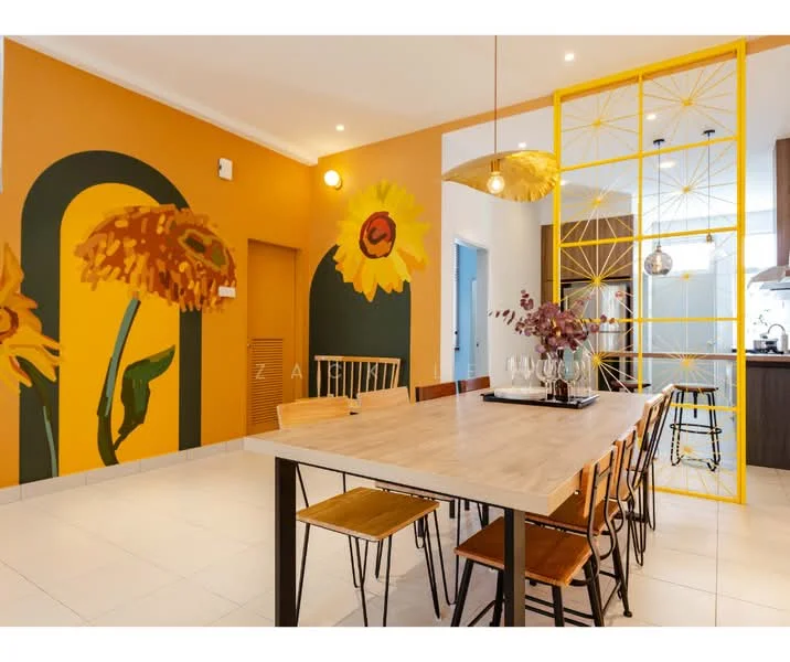 Dining features: large wooden dining table, 8 wooden dining chairs, yellow accent wall with floral mural, white tiled flooring, pendant light fixture with gold finish, decorative partition with geometric design, vase with flowers on the table, wall-mounted artwork, recessed ceiling lights; style: modern.