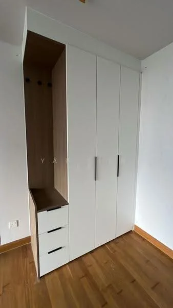 Room features: built-in wardrobe with white doors, wooden drawer unit with three drawers, wooden accent panel, light wood flooring, plain white walls, ceiling light fixture; style: modern.