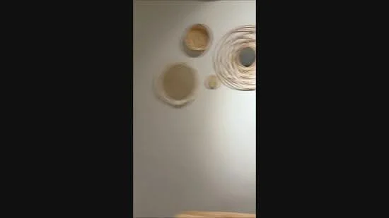 Room features: decorative wall hangings, neutral wall color, wooden table; style: minimalist.