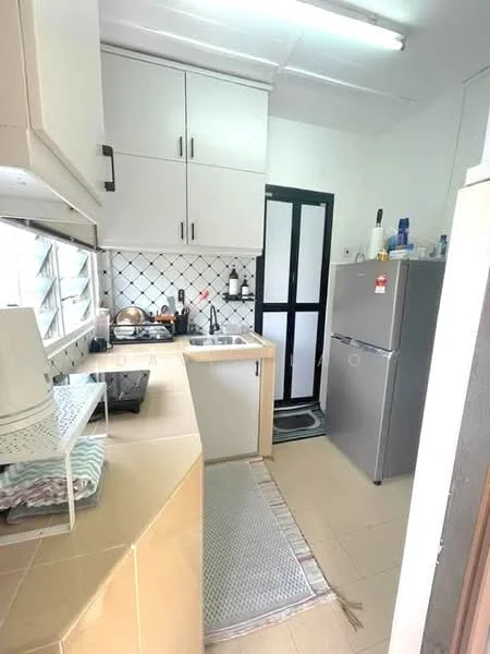 Kitchen features: white cabinetry, stainless-steel sink, chrome faucet, countertop with beige surface, black stove, grey refrigerator, tile backsplash with black and white pattern, window with grid design, floor tiles in light beige, kitchen mat, open shelving, kitchen utensils on countertop; style: modern.