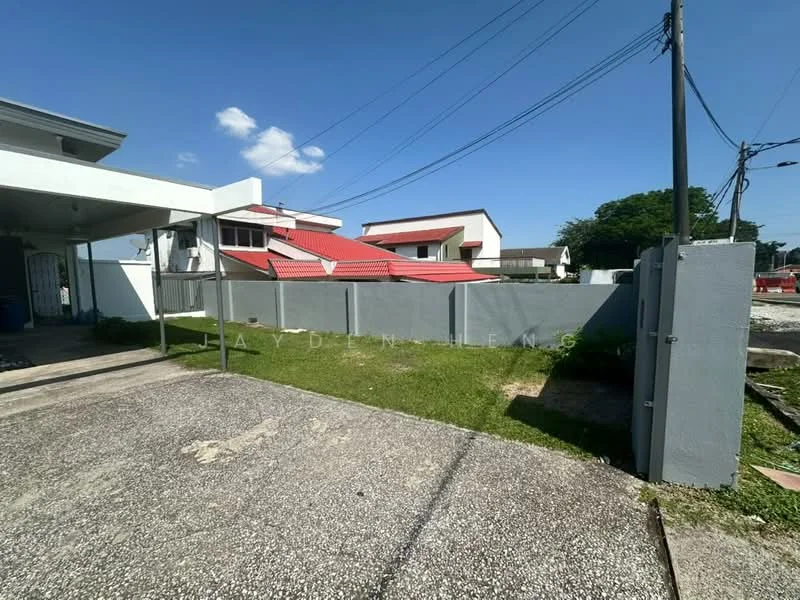 Exterior type: detached bungalow; features: grey painted fence, manicured lawn, gravel driveway, single-storey building, red pitched tile roof, surrounded by greenery, clear blue sky; style: modern.