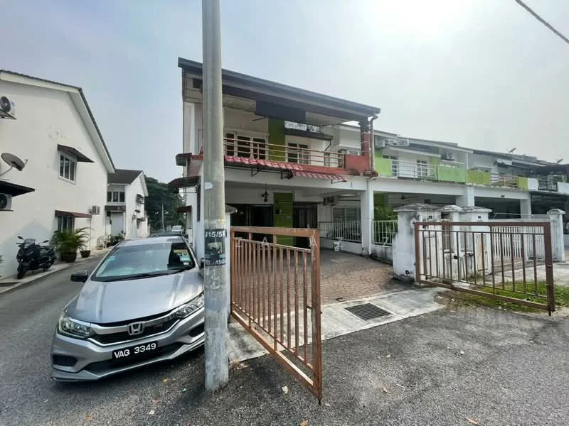 Exterior type: semi-detached house; features: two-storey structure, white painted facade, green accent wall, recessed balconies, metal railing on balcony, paved driveway, gated entrance, front garden area, multiple air conditioning units visible, car parked in driveway, fence surrounding property; style: modern.