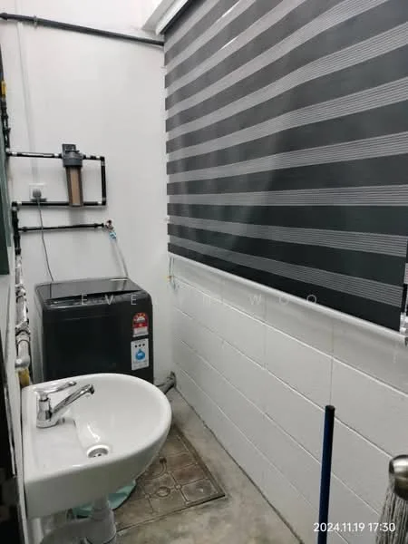 Laundry features: white painted walls, grey tiled flooring, single-bowl sink, chrome faucet, washing machine, black roller blinds, exposed plumbing, utility shelving.