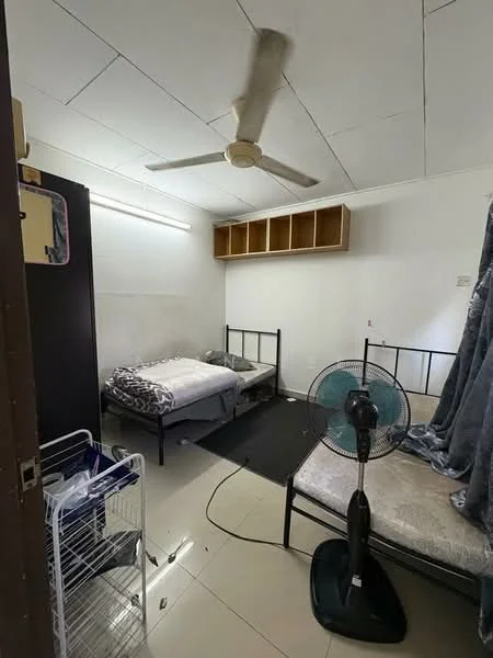 Bedroom features: two single beds with metal frames, ceiling fan, white painted walls, tile flooring, built-in shelving unit above beds, black area rug, standing fan, wardrobe, curtains, light fixture.