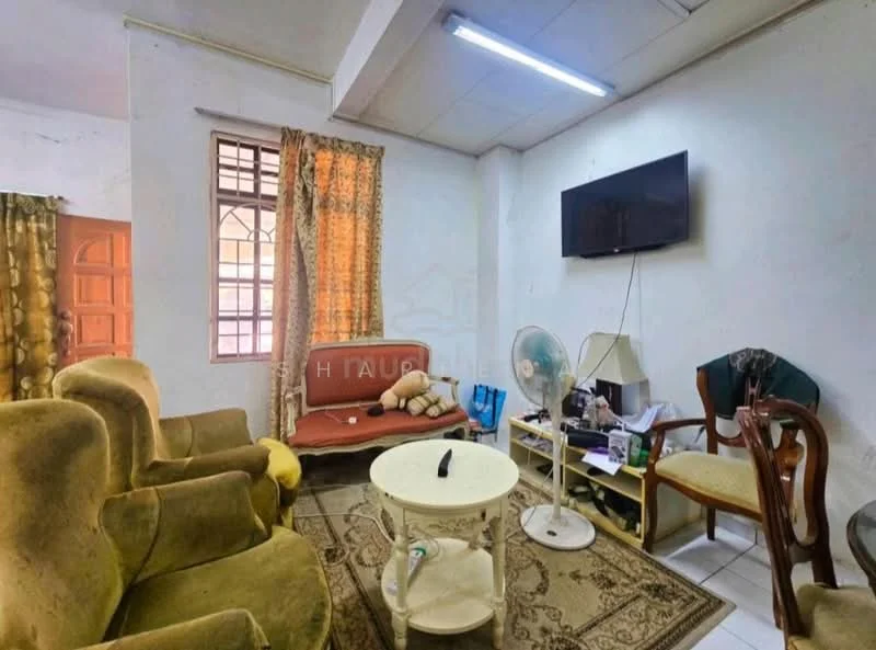 Living features: green upholstered armchairs, red upholstered sofa, white circular coffee table, wall-mounted TV, floor fan, curtains with floral pattern, tile flooring, window with grid pattern, decorative items on table.