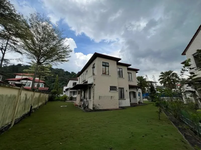 Exterior type: detached bungalow; features: white painted facade, two-storey building, flat roof, manicured lawn, mature trees, surrounded by greenery, outdoor patio area, windows with black frames, side entrance, garden area, fenced perimeter; style: modern.