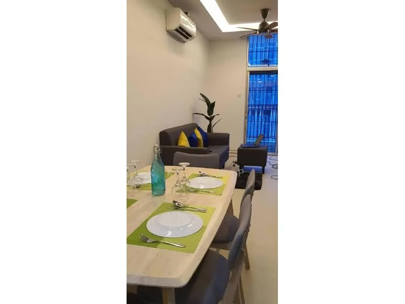 Dining features: 6-seater dining table, wooden dining table, grey upholstered dining chairs, green placemats, cutlery set, glass water bottle, decorative plant, wall-mounted split AC; style: modern. Living features: 3-seater fabric sofa in dark grey, blue and yellow decorative cushions, floor-to-ceiling windows, curtains, ceiling fan with light, side table; style: modern.