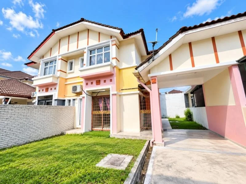 Exterior type: semi-detached house; features: double-storey, cream painted facade, pink and yellow exterior accents, white trim, vertical orange decorative bands, pitched tile roof, recessed balconies, white-framed windows, covered car porch with awning, driveway with concrete paving, manicured lawn, front yard grass, boundary wall, gated front entrance, surrounded by residential houses; style: contemporary.