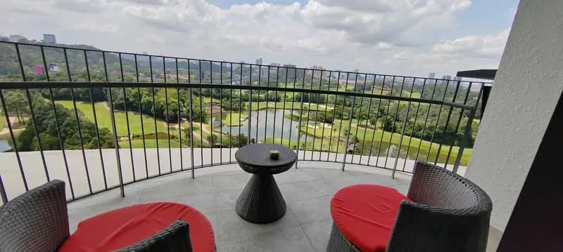 Balcony features: outdoor seating with red cushions, round coffee table, metal railing, tile flooring, view of golf course, view of water body, landscaped greenery, cloudy sky; style: modern; view: garden.