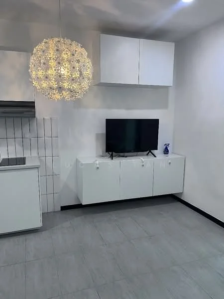 Living features: white wall cabinets, flat-panel white cabinetry, black TV console, wall-mounted TV, chandelier with decorative light, grey tile flooring, kitchenette with countertop, stainless-steel kitchen hood, white tiled backsplash; style: modern.