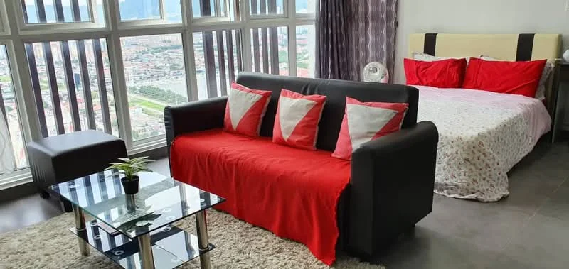 Living features: black fabric sofa with red and white cushions, glass coffee table, area rug, floor-to-ceiling windows, city view, grey curtains, bed with red and white bedding, small potted plant; style: modern; view: city.