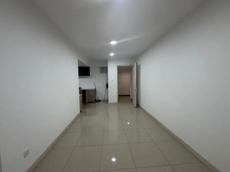Room features: white painted walls, glossy ceramic tile flooring, recessed downlights, open layout, doorway leading to another room, kitchen area visible in the background, neutral color scheme; style: modern.