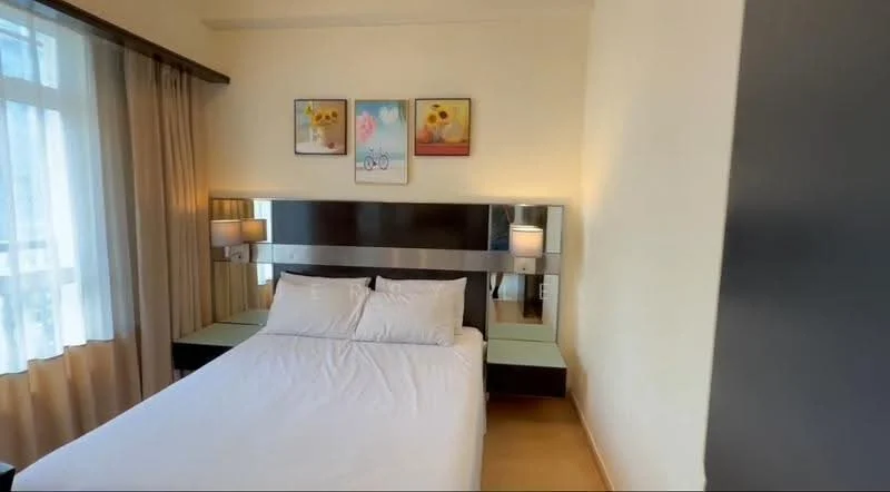 Bedroom features: queen-size bed, upholstered headboard, bedside lamps, wall-mounted artwork, floor-to-ceiling windows, sheer curtains, wooden flooring, built-in bedside tables, mirror panel behind headboard; style: modern.