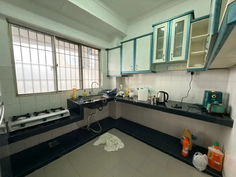 Kitchen features: white tiled walls, black tiled flooring, blue cabinetry, stainless-steel gas hob with three burners, double-bowl stainless-steel sink, chrome faucet, built-in countertop, window with metal grille, kettle, water dispenser, cleaning supplies, dish rack.