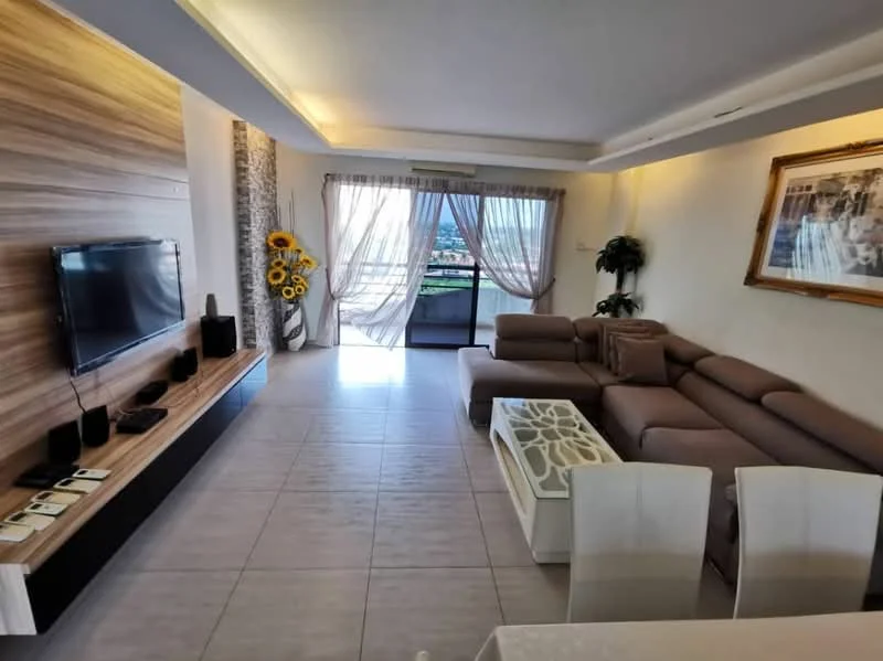 Living features: L-shape sectional sofa in beige, coffee table with decorative design, wall-mounted TV, wood feature wall, large windows with sheer curtains, tile flooring, recessed ceiling lights, decorative wall art, sunflower decor, open layout to balcony view; style: modern; view: city.