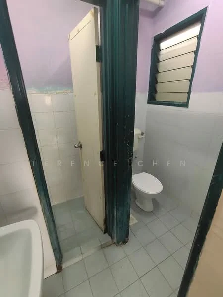 Bathroom features: white tiled walls, light blue painted walls, grey floor tiles, toilet, sink, window with louvered shutters, door, light fixture.