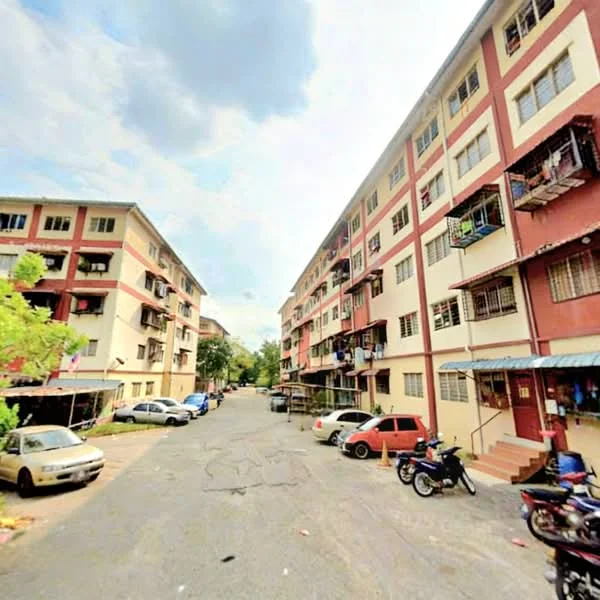 Exterior type: low-rise apartment block; features: 3-storey building, red and white painted facade, balconies with railings, asphalt road, parking spaces visible, surrounded by greenery, multiple vehicles parked, street view; style: traditional.