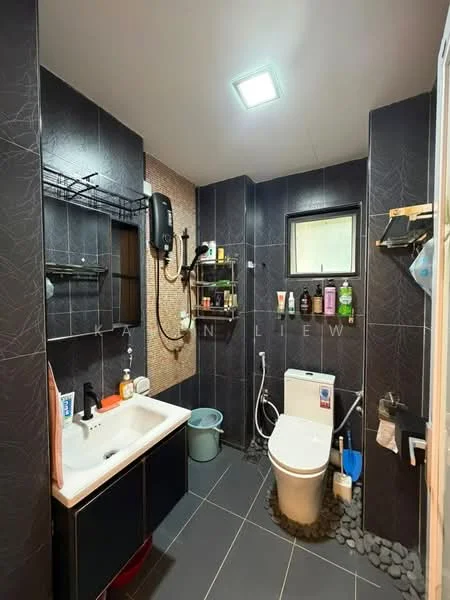 Bathroom features: black tiled walls, grey tiled flooring, single-bowl white ceramic sink, chrome basin mixer faucet, wall-mounted mirror, one-piece toilet, shower area with handheld shower, shower head mounted on wall, shelf for toiletries, toilet paper holder, waste bin, cleaning tools, small window for ventilation, LED ceiling light; style: modern.