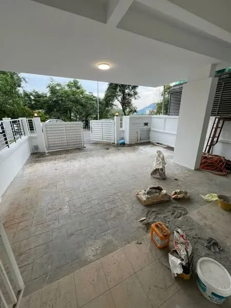 Room features: grey tiled flooring, white painted walls, ceiling light fixture, outdoor space, fenced perimeter, landscaped greenery visible, construction materials on the floor, ladder visible, unfinished area; style: modern; view: garden.