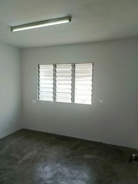 Room features: white painted walls, concrete flooring, sliding louvered windows, fluorescent ceiling light.