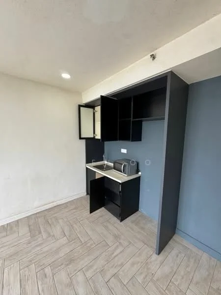 Kitchen features: black cabinetry, white countertop, sink, microwave, open shelving, tile backsplash, recessed downlights, wood-look tile flooring, grey accent wall; style: modern.