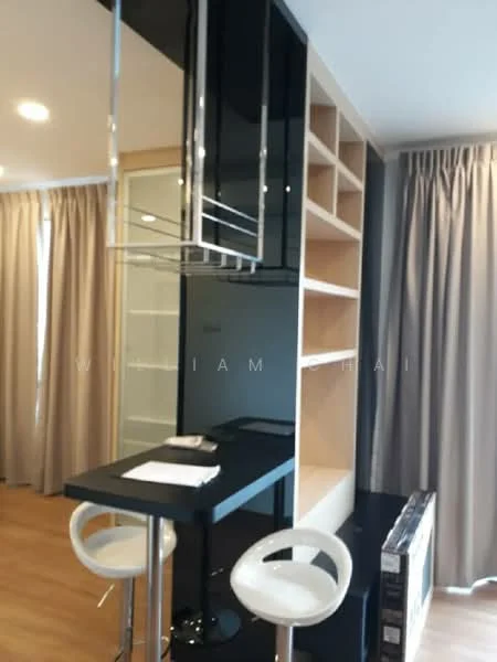 Kitchen features: black glass cabinetry, open shelving, bar counter with high stools, wooden flooring, recessed downlights, curtains, white bar stools, kitchen countertop; style: modern.