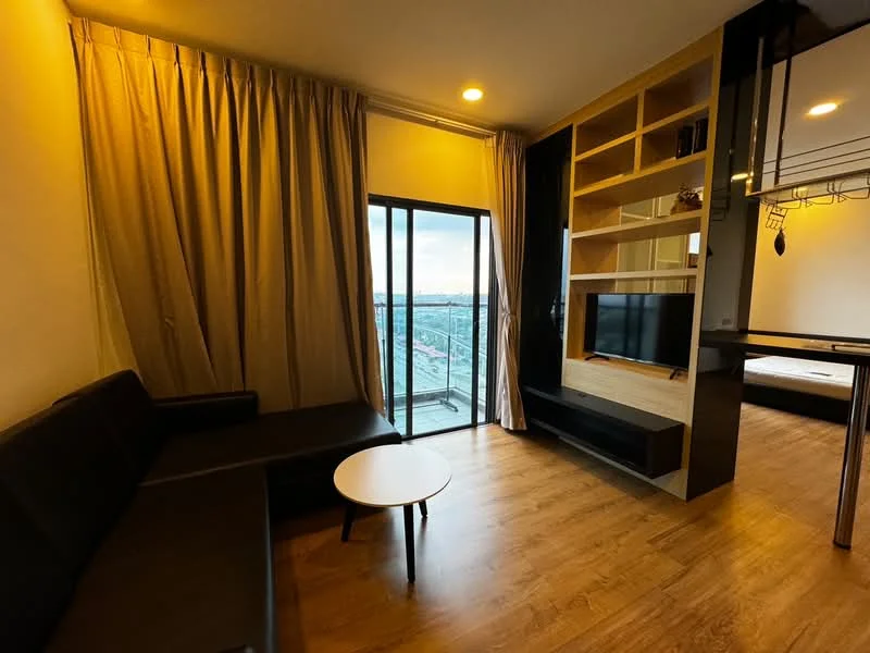 Living features: black L-shape sectional sofa, round white coffee table, floor-to-ceiling windows, sheer curtains, wood laminate flooring, TV console, wall-mounted TV, open shelving unit, decorative wall panel, recessed lighting; style: modern; view: city.