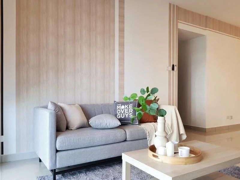 Living features: light grey fabric sofa, decorative throw pillows, wooden coffee table, ceramic vase, green potted plant, wall with wood paneling, cream painted walls, glossy tile flooring, natural light from window, decorative wall art; style: modern.
