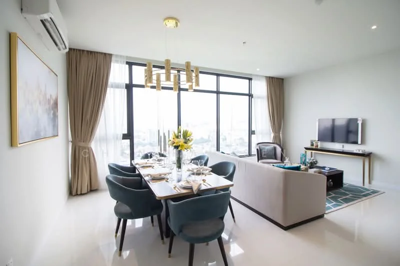 Dining features: 6-seater dining table, upholstered dining chairs in teal, chandelier light fixture, floor-to-ceiling windows, sheer curtains, decorative wall art, vase with flowers, white walls, polished tile flooring, air conditioning unit; style: modern; view: city. Living features: 3-seater fabric sofa in light grey, coffee table, TV console, wall-mounted TV, area rug with geometric pattern, decorative accessories, white walls, polished tile flooring; style: modern; view: city.