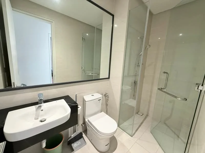 Bathroom features: single-sink vanity with black countertop, chrome basin mixer faucet, framed mirror, one-piece toilet, walk-in shower with glass enclosure, rain shower head, tile cladding on walls, white tiled flooring, glass shower door, towel rail; style: modern.