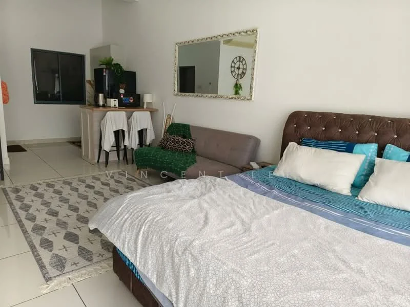 Room features: king-size bed with tufted headboard, white bedding with blue and grey accents, sofa in grey fabric, area rug with geometric pattern, wall-mounted mirror, small dining table with two chairs, kitchenette with countertop, white walls, tile flooring, window with sheer curtains, decorative wall clock; style: modern.