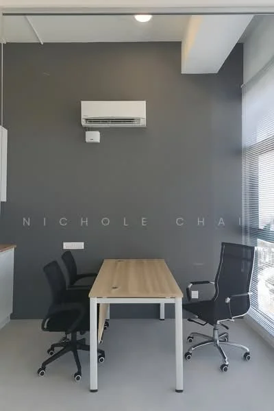 Room features: grey accent wall, white ceiling, 2 office chairs in black, wooden table with white legs, wall-mounted air conditioning unit, large window with blinds, concrete flooring; style: modern; view: city.