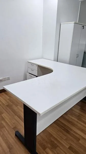 Study features: white desk with curved edge, wooden flooring, white cabinetry, drawers under desk, white walls, natural light from window, minimalist decor; style: modern.