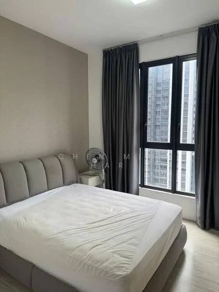 Bedroom features: king-size bed, upholstered headboard, grey bedding, floor-to-ceiling windows, blackout curtains, light grey accent wall, wooden flooring, ceiling light, nightstand, table fan; style: modern; view: city.