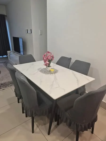 Dining features: marble dining table, 6-seater dining table, upholstered dining chairs in grey, decorative flower vase, white painted walls, tile flooring, wall-mounted TV, curtains; style: modern.