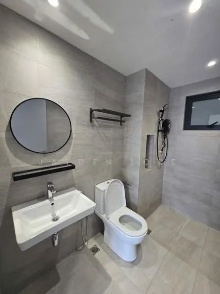 Bathroom features: grey tiled walls, grey tiled flooring, round mirror, wall-mounted sink, chrome faucet, one-piece toilet, shower area with glass partition, wall-mounted shower head, handheld shower, black towel rack, black shower fixtures, recessed lighting; style: modern.