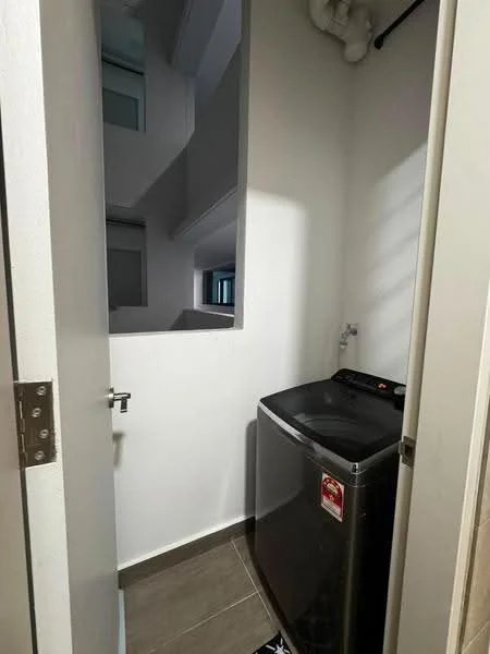 Laundry features: front-load washing machine in black, grey tiled flooring, white painted walls, window for natural light, plumbing fixtures, door leading to hallway.