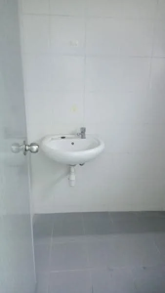 Bathroom features: white wall tiles, grey floor tiles, wall-mounted sink, chrome faucet, mirror above sink, light fixture, toilet paper holder, door handle.