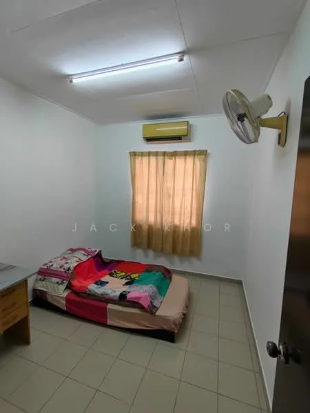 Bedroom features: single bed with colorful bedding, cream painted walls, tile flooring, window with sheer curtains, wall-mounted air conditioning unit, ceiling fan, wooden bedside table, light fixture on ceiling.