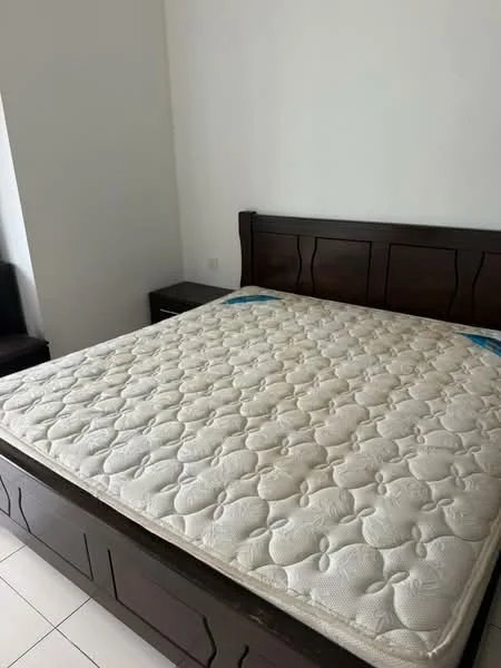 Bedroom features: queen-size bed, wooden bed frame, mattress with quilted cover, white painted walls, tile flooring, nightstand, window with natural light, minimalist decor; style: modern.