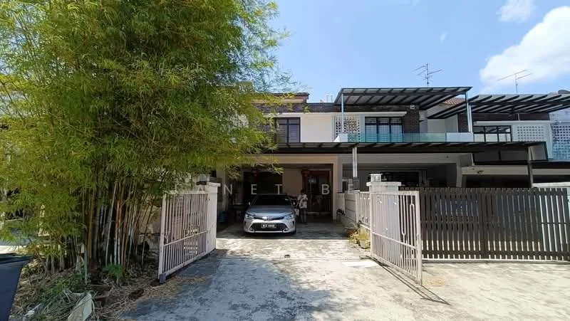 Exterior type: linked terrace house; features: two-storey building, grey painted facade, flat roof, car porch with awning, manicured lawn, bamboo plants, paved driveway, fence with gate, balcony on upper floor, visible windows, surrounded by greenery; style: modern.