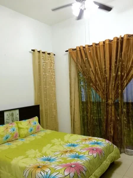 Bedroom features: queen-size bed with floral bedding, two decorative pillows, ceiling fan with 5 blades, white painted walls, brown sheer curtains, dark brown curtains, tile flooring, bedside table with floral design.