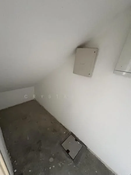 Room features: white painted walls, sloped ceiling, concrete flooring, electrical panel on wall, small access hatch on floor.