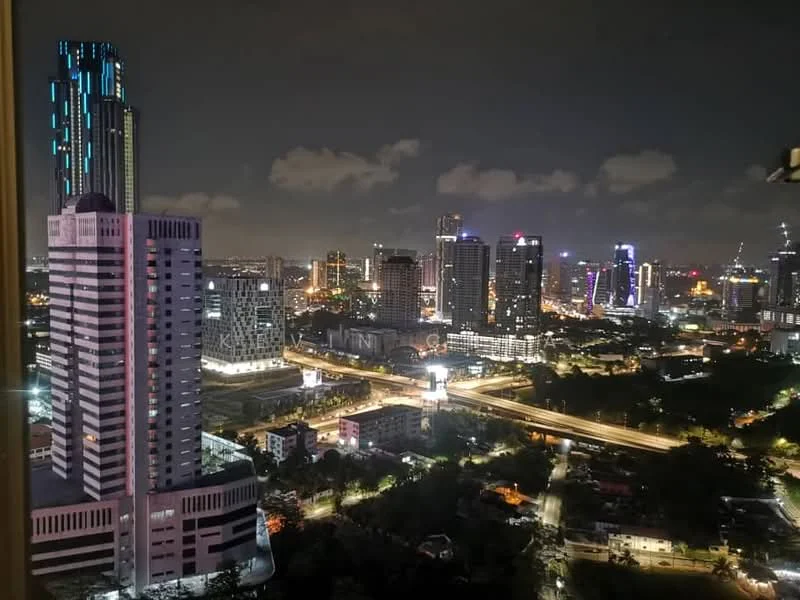 Exterior type: high-rise condominium; features: city skyline view, illuminated buildings, highway visible, nighttime lighting, modern architecture, surrounded by urban landscape; style: modern.