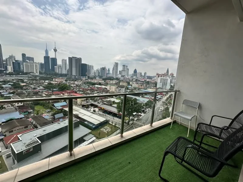 Balcony features: glass railing, artificial grass flooring, two black metal chairs, city skyline view, overcast sky; style: modern; view: city.