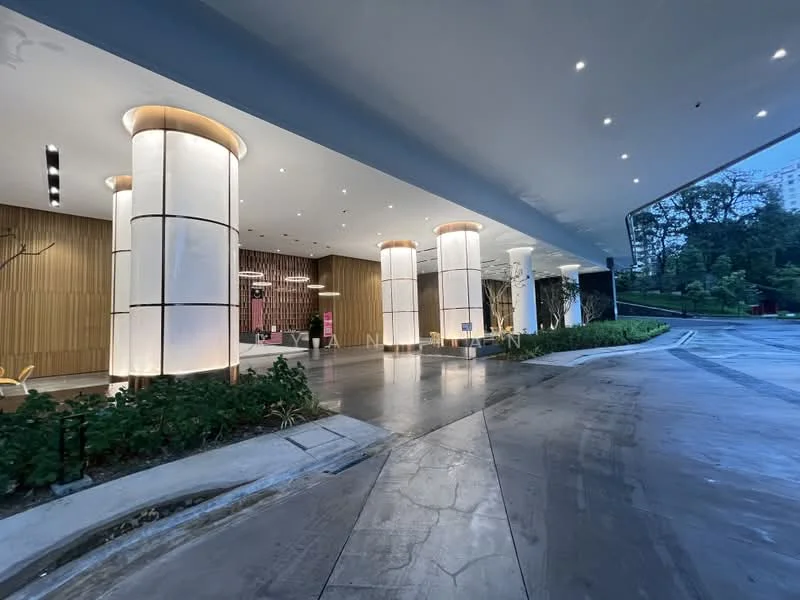 Exterior type: high-rise condominium; features: modern facade with large columns, glass entrance, wood paneling, recessed lighting, landscaped greenery, smooth concrete driveway, paved walkway, illuminated columns; style: modern.