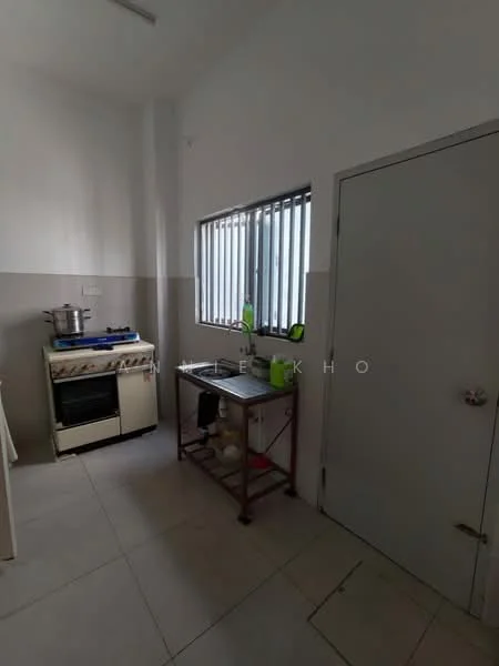 Kitchen features: white painted walls, grey painted walls, tile flooring, gas stove with oven, stainless-steel pot on stove, metal shelving unit, window with horizontal bars, door, sink, countertop space.