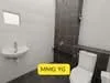 Bathroom features: white painted walls, grey tile flooring, single-sink vanity with wood cabinet, chrome basin mixer faucet, one-piece toilet, framed mirror, window for natural light, shower area with glass partition; style: modern.