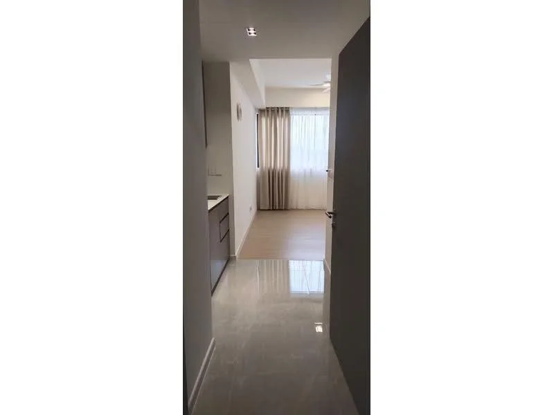 Room features: white painted walls, light-colored flooring, recessed downlights, floor-to-ceiling window with sheer curtains, open layout, kitchen cabinetry visible, doorway leading to another room; style: modern.