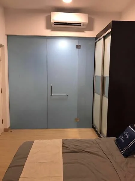 Bedroom features: wooden flooring, wall-mounted split AC, glass sliding door, built-in wardrobe with frosted glass panels, bed with grey bedding, decorative pillow, white painted walls, recessed ceiling lights; style: modern.